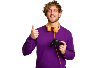 Young caucasian gamer man holding a game controller isolated on white background smiling and raising thumb up