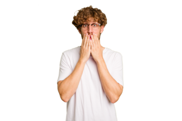 Young caucasian man isolated on green chroma background shocked, covering mouth with hands, anxious to discover something new.