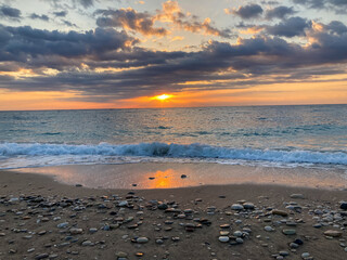 Sunrise landscape with clouds and sea. View of the sun rising above the sea. Selective focus.