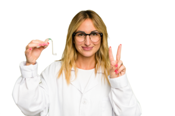 Young otorhinolaryngologist caucasian woman holding hearing aid isolated on green chroma background showing number two with fingers.