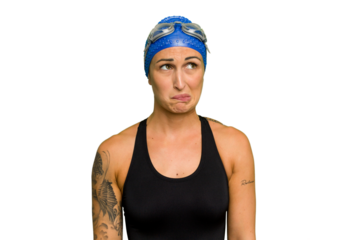 Young caucasian swimmer woman isolated on green chroma background confused, feels doubtful and unsure.