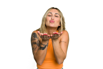 Young caucasian woman isolated on green chroma background folding lips and holding palms to send air kiss.