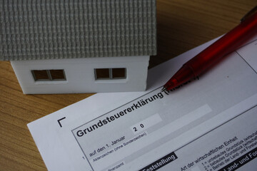 Formular Grundsteuererklärung mit einem Stift und Haus