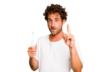 Young caucasian man holding an electric toothbrush isolated having an idea, inspiration concept.