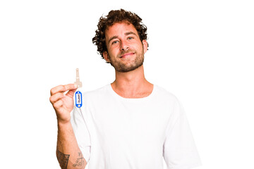 Young caucasian man holding home keys isolated happy, smiling and cheerful.