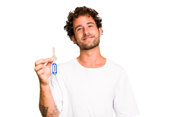 Young caucasian man holding home keys isolated happy, smiling and cheerful.
