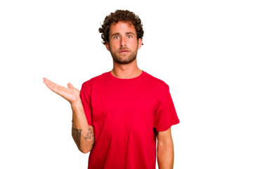 Young caucasian curly hair man isolated Young caucasian man with curly hair isolated impressed holding copy space on palm.