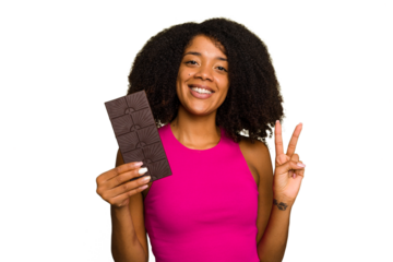 Young African American woman holding a chocolate bar isolated showing number two with fingers.