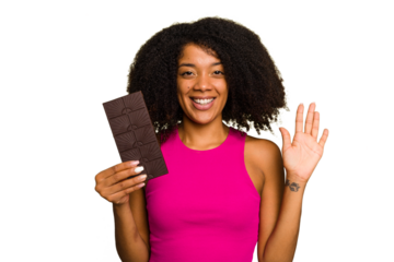 Young African American woman holding a chocolate bar isolated smiling cheerful showing number five with fingers.