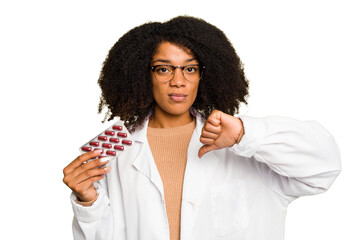 Young pharmacist African American woman holding a tablet of pills isolated showing a dislike...