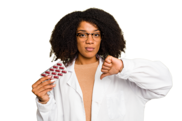Young pharmacist African American woman holding a tablet of pills isolated showing a dislike gesture, thumbs down. Disagreement concept.