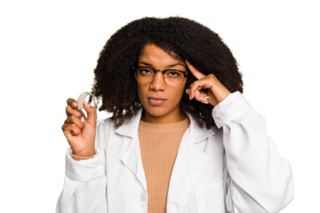 Young otorhinolaryngologist African american woman holding hearing aid isolated pointing temple with finger, thinking, focused on a task.