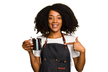 Young African American woman barista isolated person pointing by hand to a shirt copy space, proud...