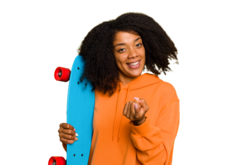 Young skater African American woman holding a little skate isolated pointing with finger at you as if inviting come closer.