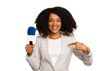 Young TV presenter African American woman with a microphone isolated person pointing by hand to a...