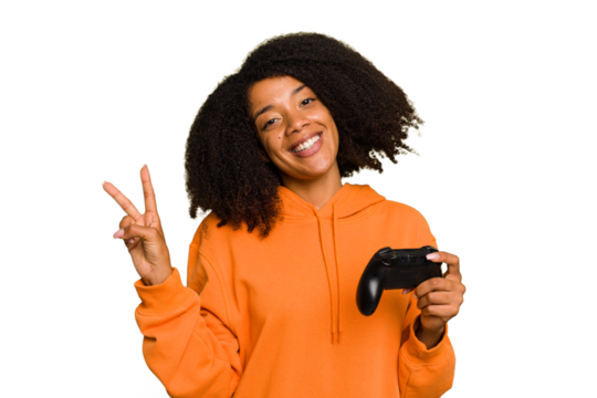 Young African American woman holding a game controller isolated joyful and carefree showing a peace symbol with fingers. - Powered by Adobe