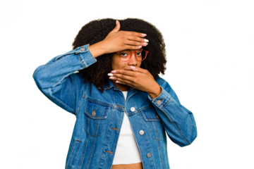 Young African American woman isolated blink at the camera through fingers, embarrassed covering face.