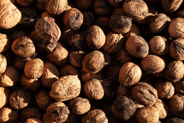 Walnuts background texture, unshelled and unprocessed healthy food, in warm autumnal tones
