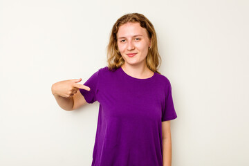 Young caucasian woman isolated on white background person pointing by hand to a shirt copy space, proud and confident