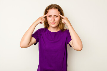 Young caucasian woman isolated on white background focused on a task, keeping forefingers pointing head.