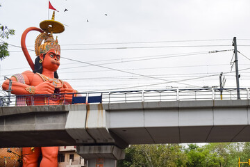 Big statue of Lord Hanuman near the delhi metro bridge situated near Karol Bagh, Delhi, India, Lord Hanuman big statue touching sky - obrazy, fototapety, plakaty