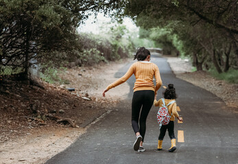 Teen running on the trial with her little sister