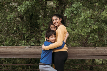 Siblings hugging each other outdoors 