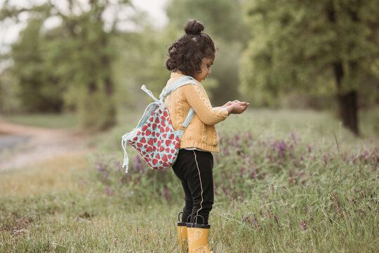 Little girl playing with dirt in her hands 