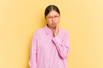 Young Asian woman isolated on yellow background having a strong teeth pain, molar ache.