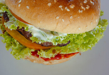 Angus burger with mayonnaise, ketchup, tomato and lettuce on sesame seed bun