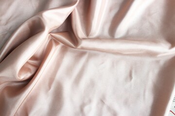 Beautiful soft beige fabric, folded in soft folds. Silk, satin or satin ribbon.