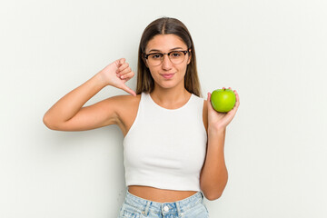 Young Indian woman holding an apple isolated on white background feels proud and self confident, example to follow.