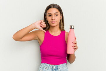 Young indian woman holding a pink thermo isolated on white background showing a dislike gesture, thumbs down. Disagreement concept.