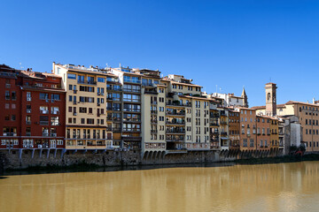 Fototapeta premium Townhouses and historic buildings on the Arno River in the city of Florence