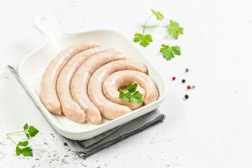Fresh turkey sausages on white plate. Top view, copy space.