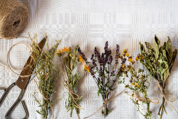 Various dry herbs tea bunches on a linen canvas. Herbs you should have at home: basil, St. John's...