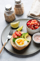 Toast with avocado, tomato salsa and egg for healthy breakfast