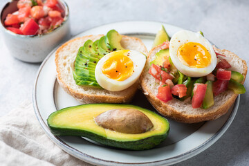 Toast with egg, tomato and avocado on a plate, healthy vegetarian food