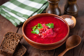 Meatless borscht soup served with rye bread on wooden table background, ukranian culture food