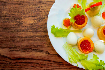 background of red caviar on dsrk wooden surface. tartlets with red caviar