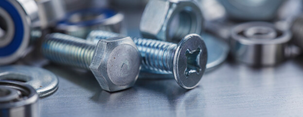 set of different nuts, bolts, screws, washers and drill bits,thread tap and mill cutters on steel plate background. Locksmithing deal.