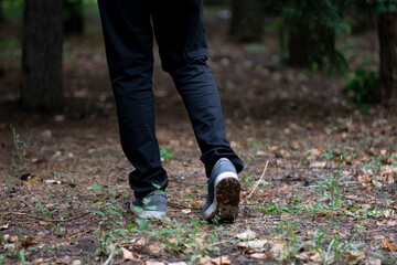 close up feet of person walking in the forest, trail hiking