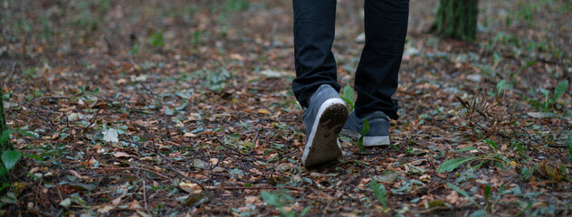 close up feet of person walking in the forest, trail hiking