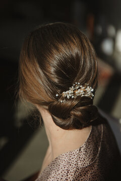 bun hairstyle with beads hair clipper of a brunettes bride