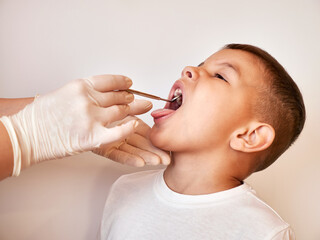 The child's teeth are examined using a dental mirror.