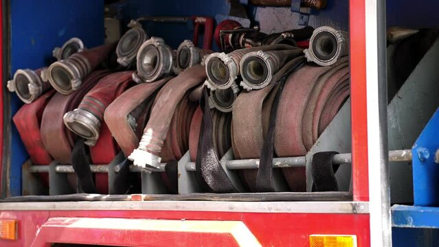 Rolled fire hoses arranged in rows, in a fire truck or fire cabinet. Fire station equipment.