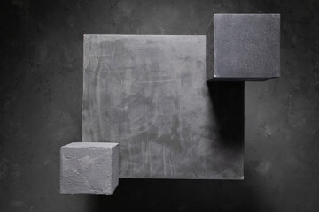 Concrete cube on abstract cement floor background texture. Geometric model concept