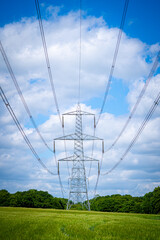 Pylon Power Electricity Electrical Distribution Aerial Cable Running through Countryside Farmer Fields with Blue Sky and White Clouds