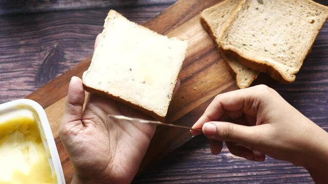  fresh butter spreading on a bread 