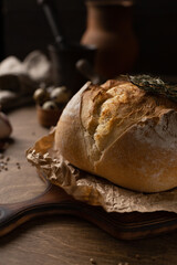 Homemade bread with parchment paper at wood table. Bread on wooden tabletop as baking concept